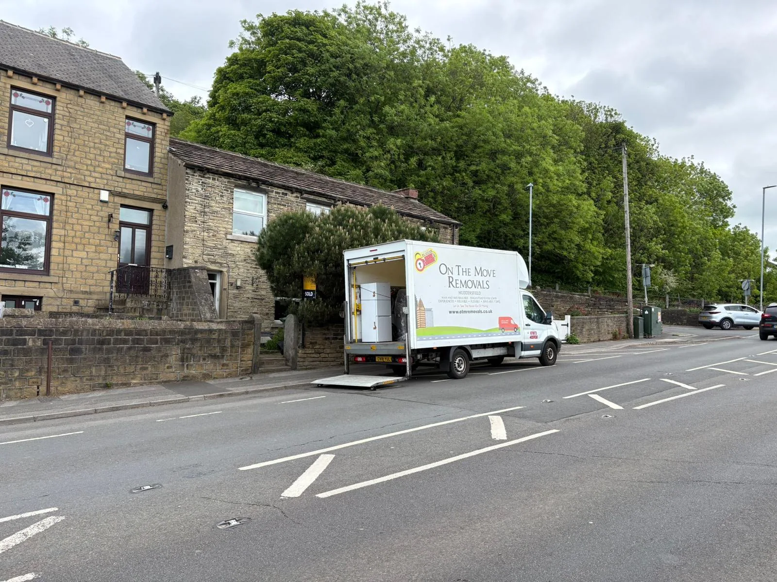 On The Move Removals Luton van outside stone terrace houses in Linthwaite, Huddersfield during a Colne Valley move