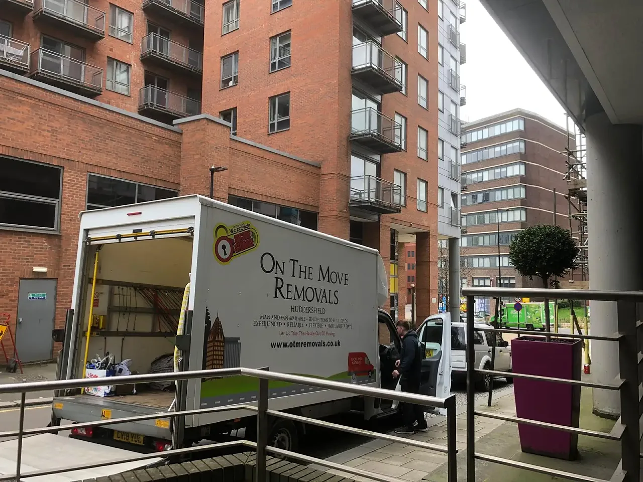 On The Move Removals team handling an upright piano next to the OTM removals van during a Huddersfield piano move