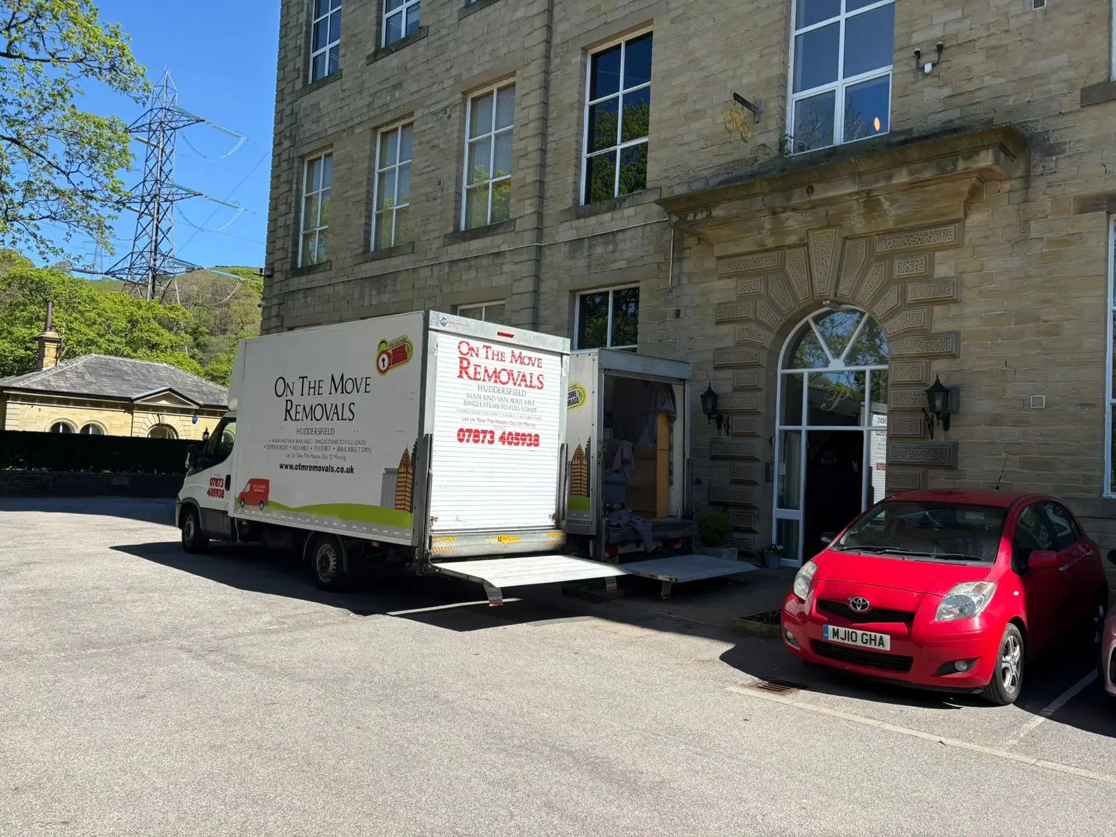 On The Move Removals van with the ramp down outside an ornate office building during a Huddersfield commercial move